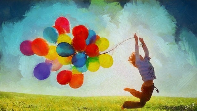Boy jumping with colorful balloons