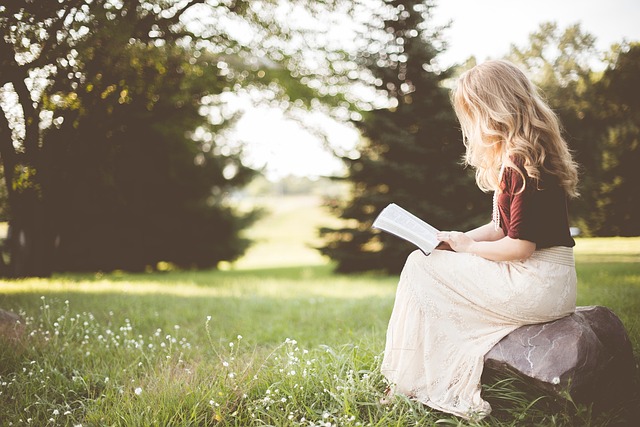 Girl reading book by her side