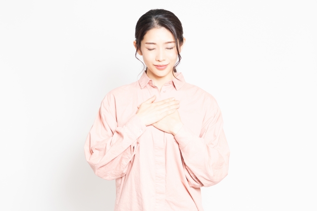 胸に手を当てる女性