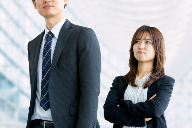 自分は悪くないと腕組みするビジネスウーマン